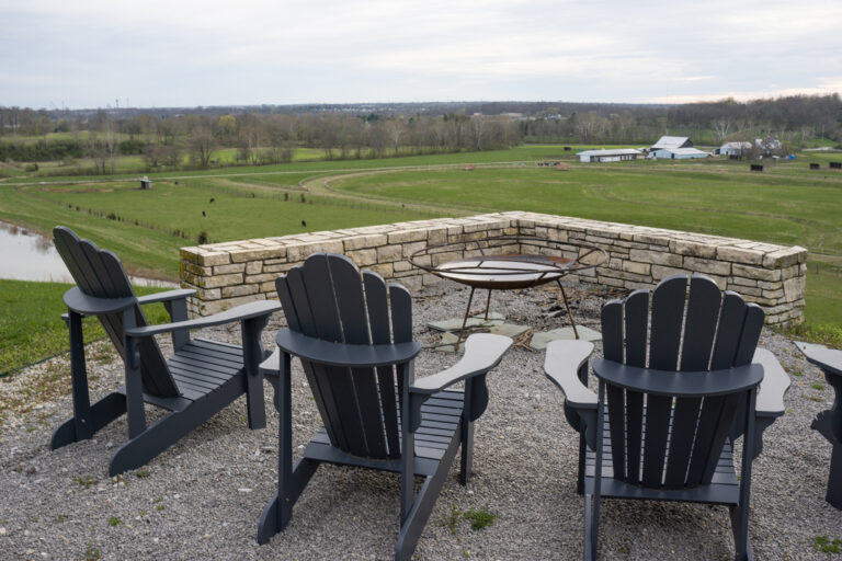 The seating around the fire pit area with the pasture beyond