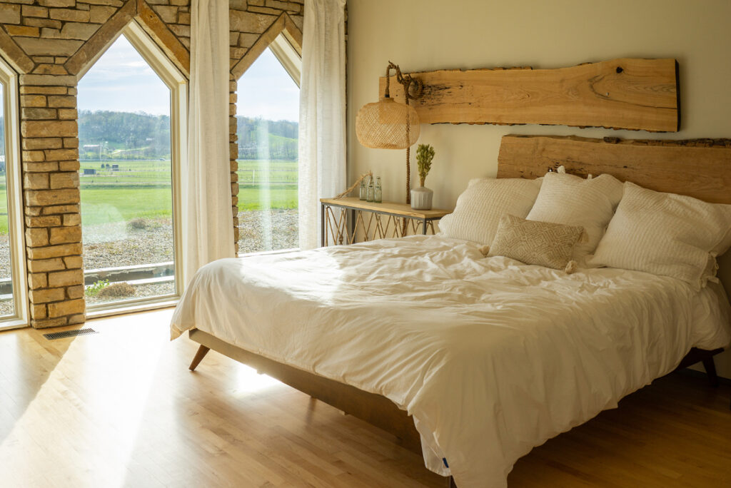 A king size bed in a large bedroom with a lot of natural light