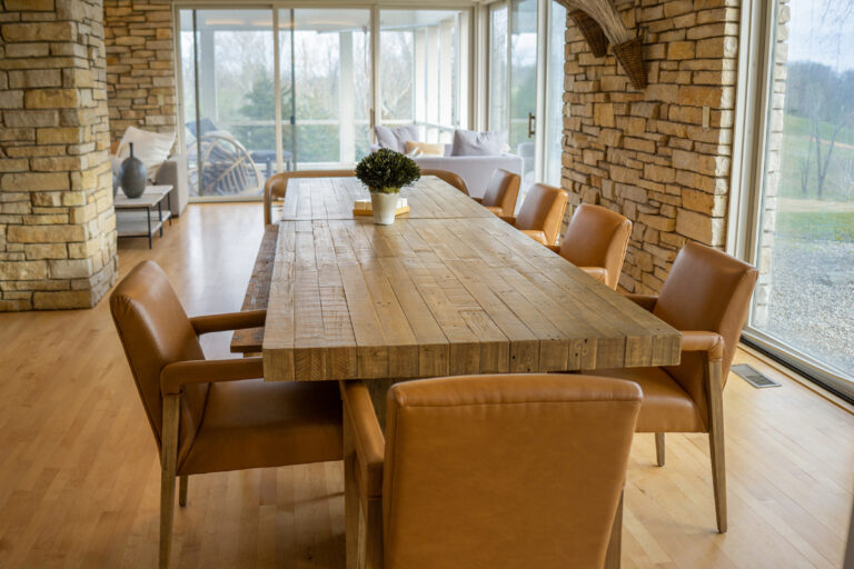 A dining area with a long, reclaimed wood table that seats 10 or more