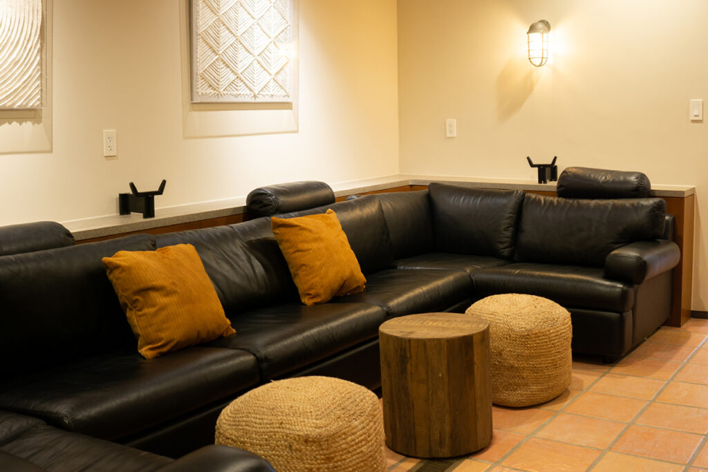 A black leather couch in a tiled living area.