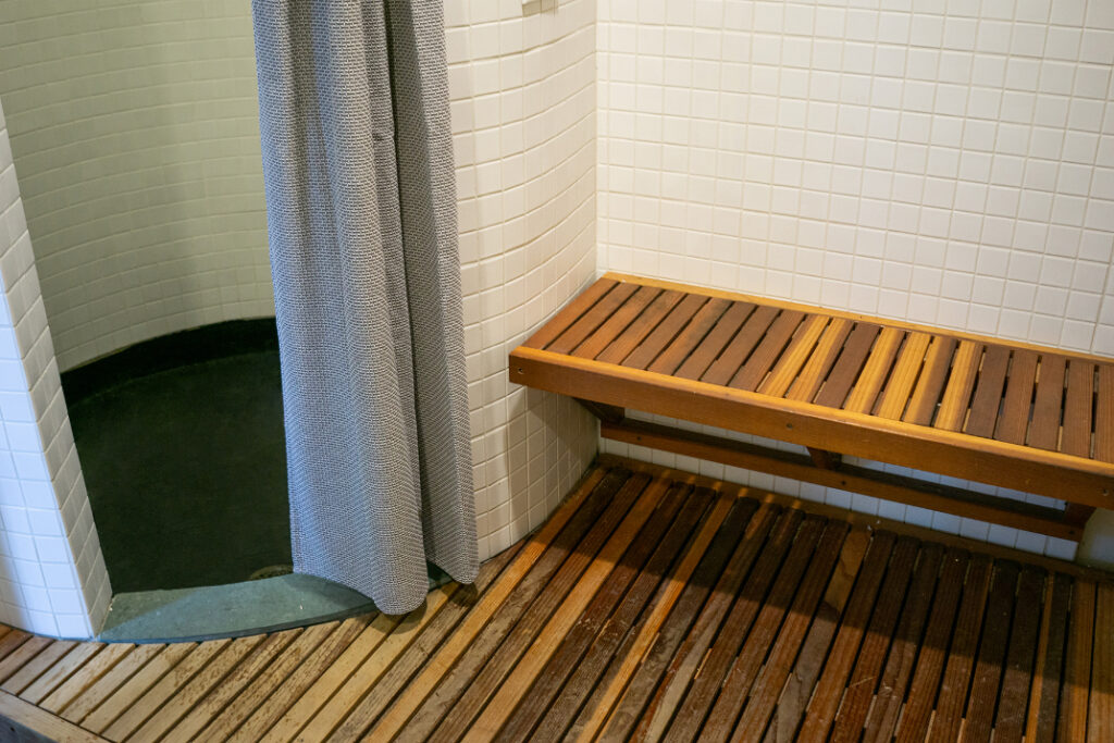A walk-in shower with a wooden bench.