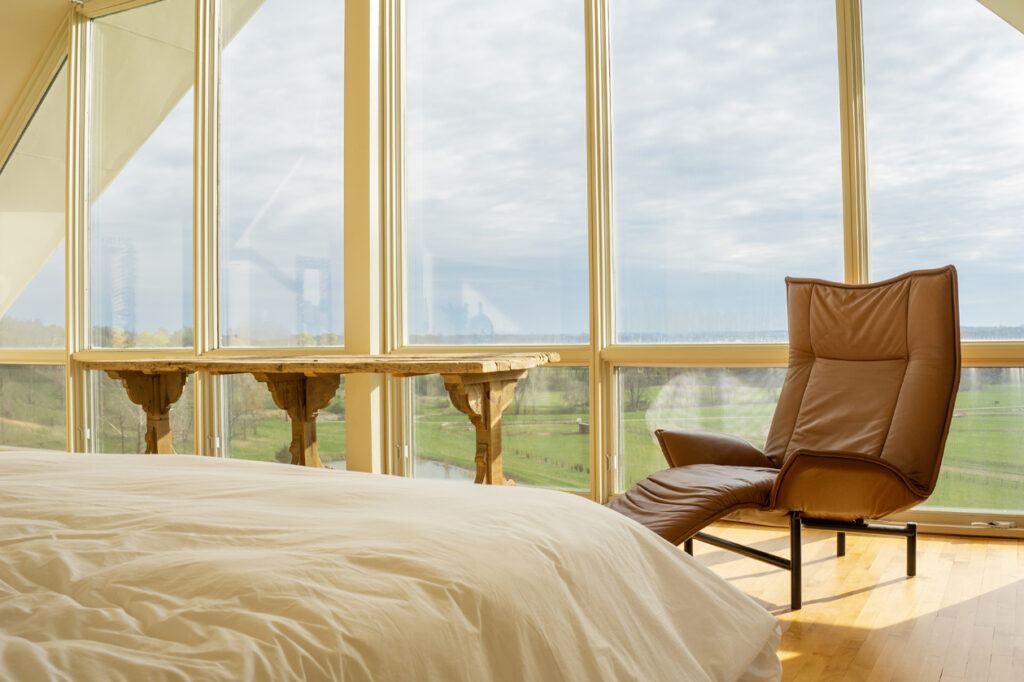 A large bedroom with huge windows overlooking Byerpatch Farm
