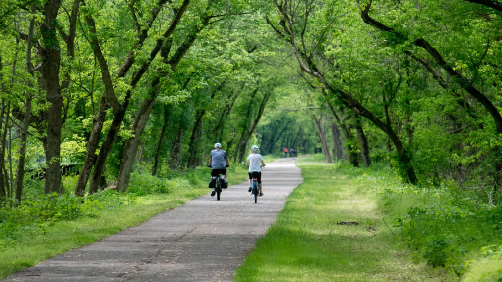 A man and a woman riding bicycles on a path on the Loveland Bike Trail.